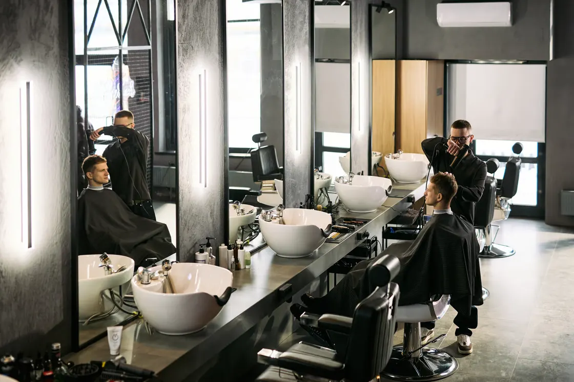 Barbershop training floor with styling chairs and wash stations