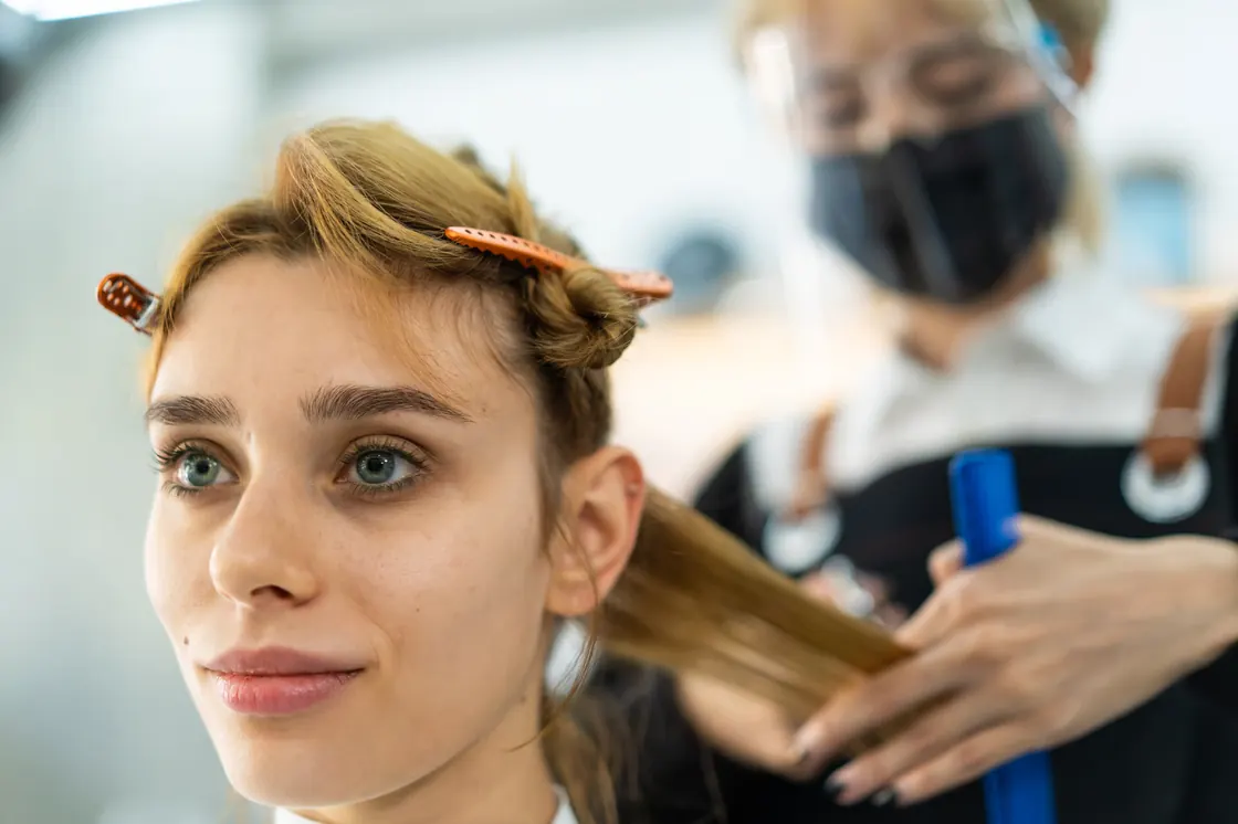 Cosmetology student with a hairstyle in progress