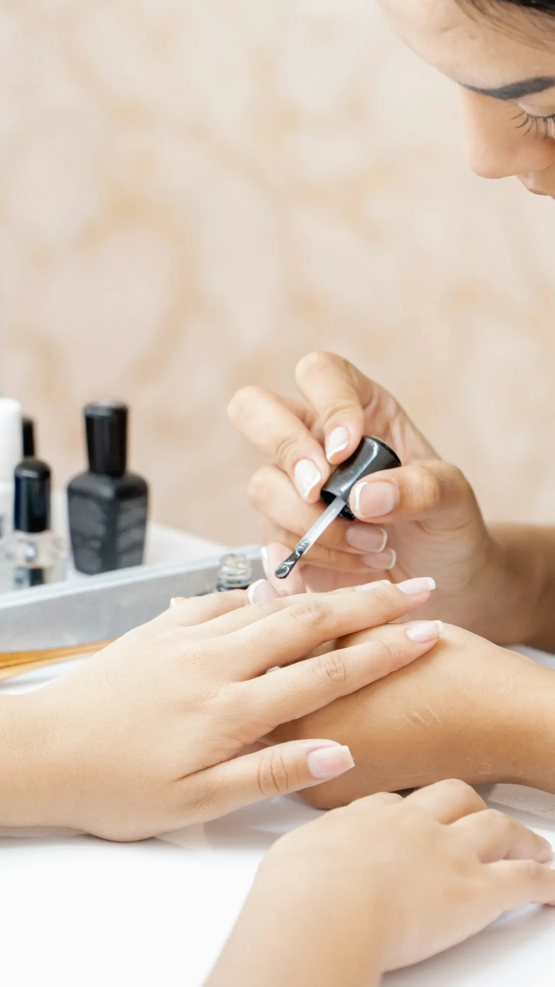 Nail technician applying polish during a professional manicure