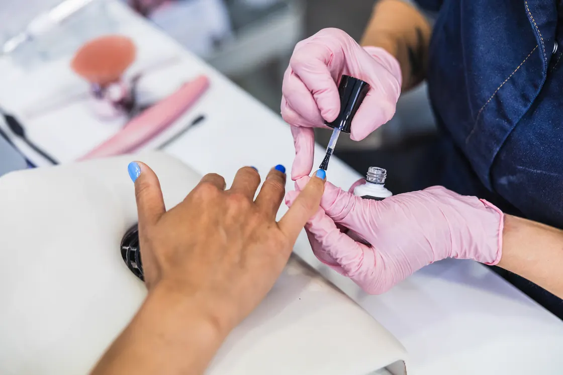 Nail technician applying polish to a client's nails