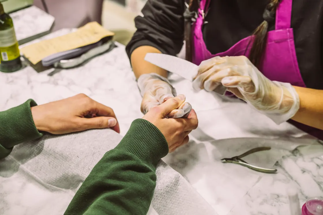 Students practicing a manicure at a work table