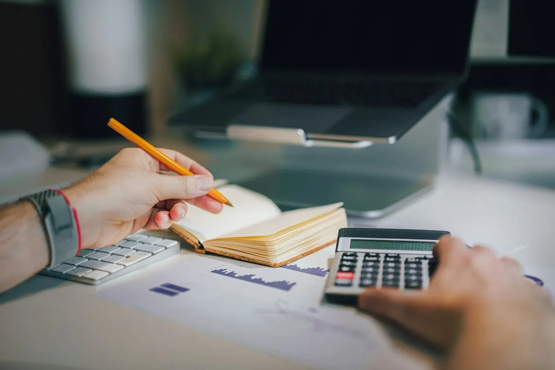 Planning a tuition budget with a calculator and notebook