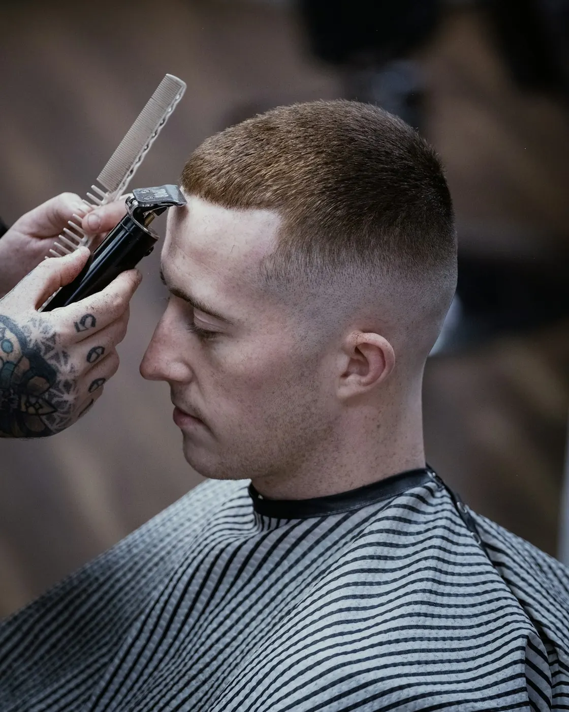 Barber giving a short military-style haircut with clippers